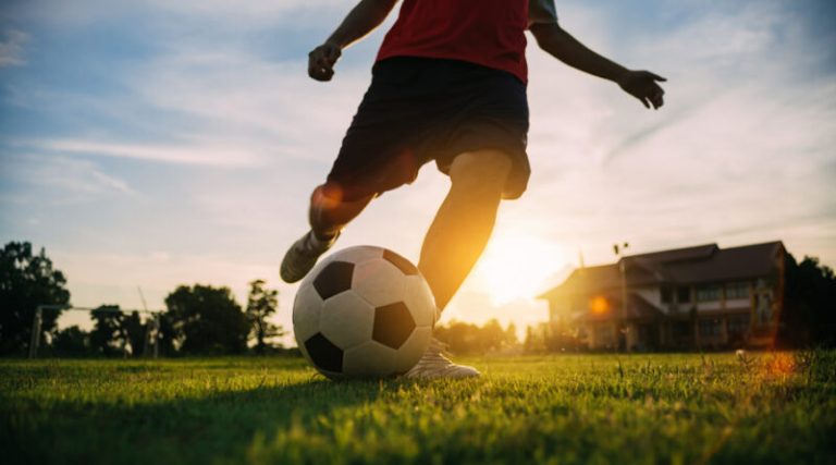 Action sport outdoors of a group of kids having fun playing socc