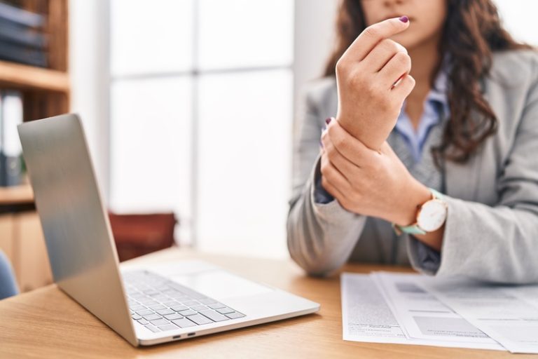 Young hispanic woman business worker suffering for wrist pain at office